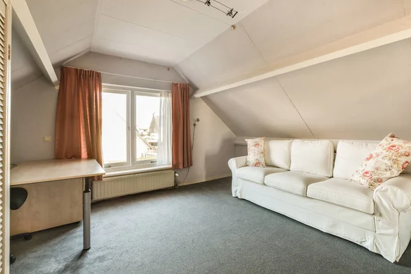 Beyaz kanepeli ve penceresinde turuncu perdeleri olan bir oturma odası fotoğrafta görülüyor.