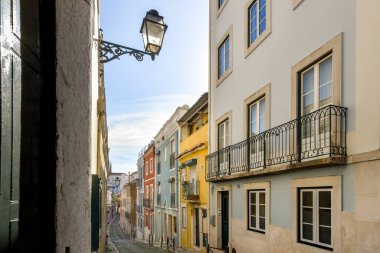 Arka planda binalar olan bir sokak ve binanın sağ tarafında da elektrik direği olan bir sokak.