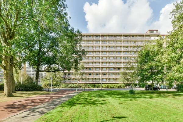 Een Appartementencomplex Met Bomen Voorgrond Groen Gras Aan Andere Kant — Stockfoto