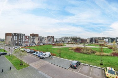 Amsterdam, Hollanda - 10 Nisan 2021: Arabalar sokağa park edilmiş ve evler arka planda, insansız hava aracından alınan - serbest görüş