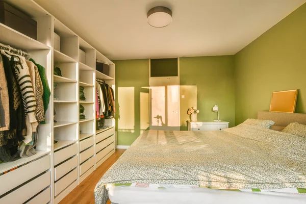 Спальня Кроватью Комод Одежда Висит Стене Перед Кроватью Зеленые Стены — стоковое фото