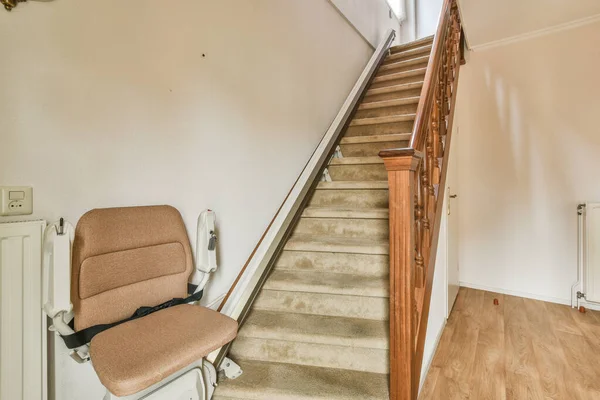 a stair with a chair on the bottom and an open door to the second floor in the stairs are empty