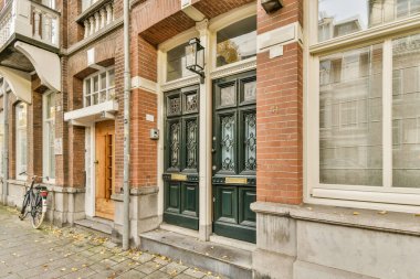 Önündeki kaldırıma parketmiş bisikleti olan tuğladan bir bina ve tüm zemine saçılmış bırakılmış.