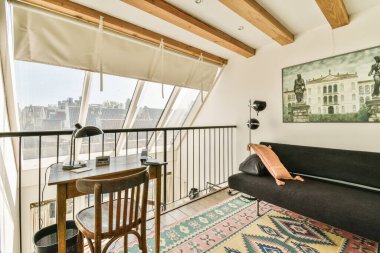 Amsterdam, Hollanda - 10 Nisan 2021: Oturma odasındaki kanepenin ve masanın yanındaki duvarda eski bir bina var.