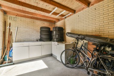 Amsterdam, Hollanda - 10 Nisan 2021: Garajın kenarına bir bisiklet park edilmiş bir garaj ve yanında da bir çamaşır makinesi.