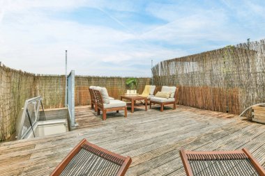 İki sandalyeli ahşap bir güverte ve ortada bir şömine var. Bir sandalye diğerinin üstünde.