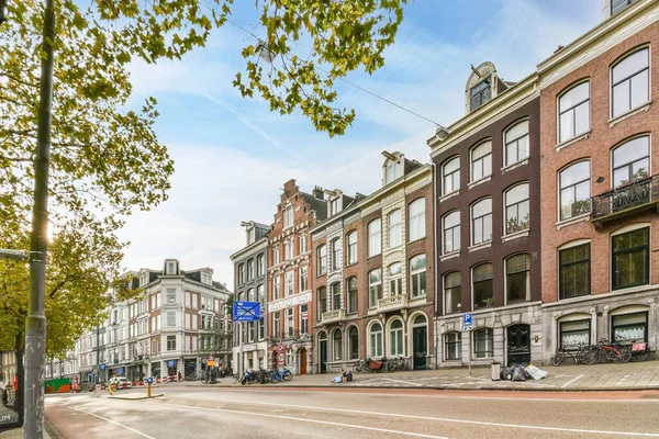 stock image a city street with many buildings and people walking on the sidewalk in front of some tall red bricked buildings