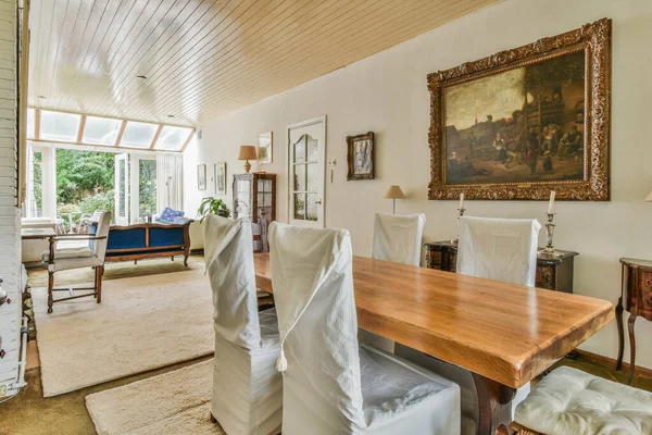 アムステルダム オランダ 2021 白い椅子と部屋の中央に木製のテーブルを備えたダイニングルームは 壁に掛けられた絵画です — ストック写真