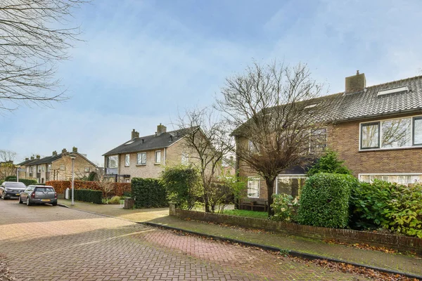 stock image Amsterdam, Netherlands - 10 April, 2021: a street with houses and trees in the fore - image was taken from an early spring day to late afternoon