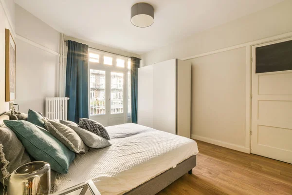 Ein Schlafzimmer Mit Holzboden Und Blauen Vorhängen Der Wand Dahinter — Stockfoto