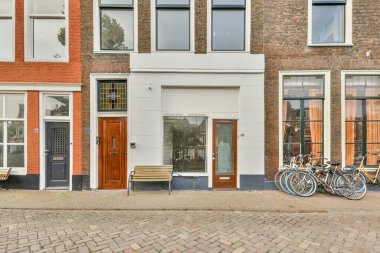 Birkaç kapısı ve penceresi olan bir caddenin kenarındaki bir binanın önüne park etmiş bir bisiklet.