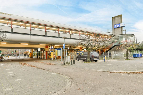 stock image Amsterdam, Netherlands - 10 April, 2021: a parking area with cars parked in the lot and people walking on the sidewalk to get their cars keys