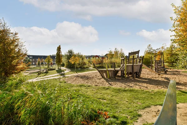 Stock image an empty playground in the middle of a residential area with lots of grass and trees on either side of the park