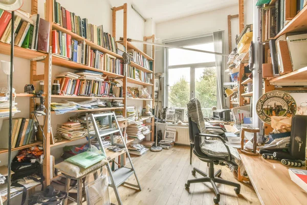 stock image a home office with lots of books on the shelves and desks in front of the window that looks out onto the street