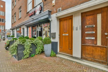 Önündeki kaldırımda bitkiler ve binanın girişi olan bir restoranın dışında.