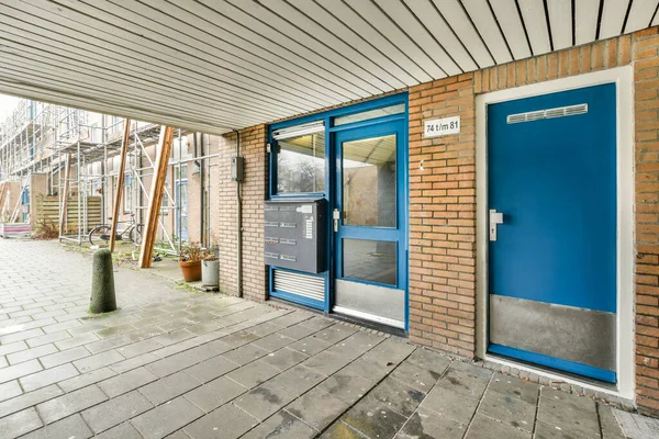 Uma Porta Azul Lado Edifício Tijolo Que Foi Pintado Com — Fotografia de Stock