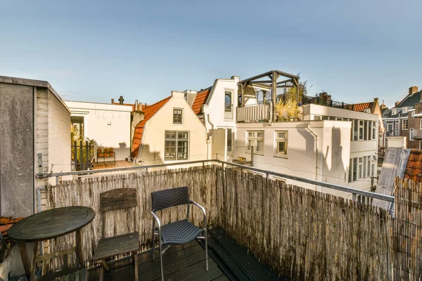 stock image an outside area with some buildings in the background and a wooden fence to the right, on a sunny day