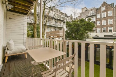 Bir apartmanın önündeki teras ve masalar beyaza boyanmış bir apartmanın önünde.