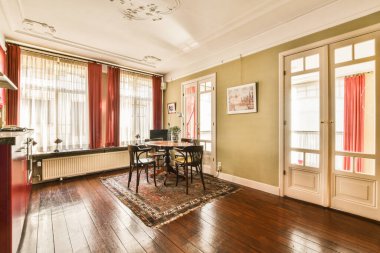 Amsterdam, Hollanda - 10 Nisan 2021: Ahşap döşemeleri ve pencerelerinde kırmızı perdeleri olan bir oturma odası