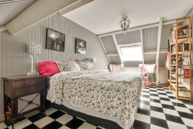 Amsterdam, Hollanda - 10 Nisan 2021: Odada siyah beyaz kareli bir yatak odası, üzerinde kırmızı yastıklar olan bir yatak odası var.