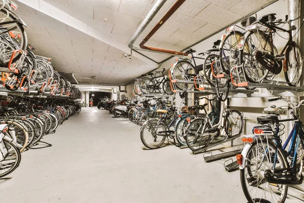many bikes parked in a bike storage area, all stacked up and ready to be stored on the wall or ceiling