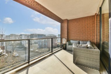 Kanepeler, sandalyeler ve manzaralı bir balkon.