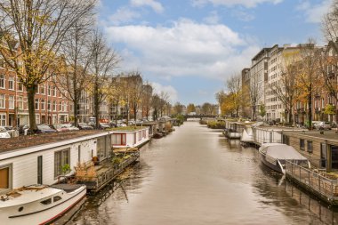 bulutlu bir günde, arka planda tekneleri ve evleri olan bir kanal, bulutlu bir gökyüzünden görüldüğü gibi.