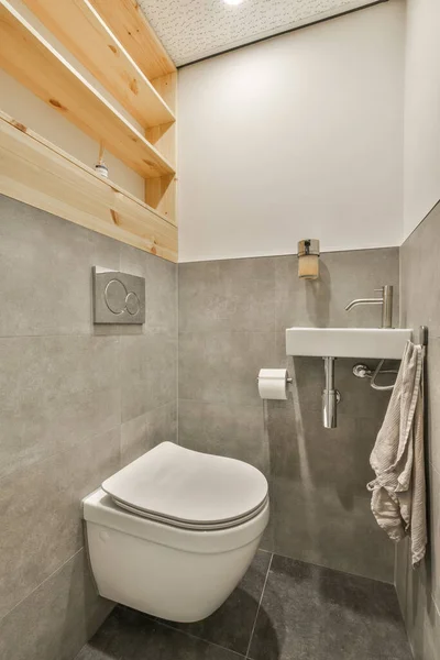 Łazienka Toaletą Umywalką Ręcznikiem Zawieszonym Ścianie Obok Znajduje Się Drewniana — Zdjęcie stockowe