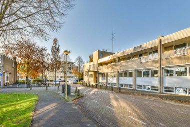 Amsterdam, Hollanda - 10 Nisan 2021: Her iki tarafında ağaçlar ve binalar olan boş bir yerleşim alanı.