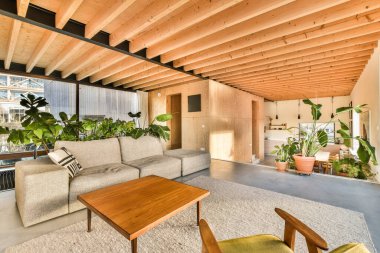 a living room with couches, tables and plants in the center of the room there is an open space for people to sit clipart