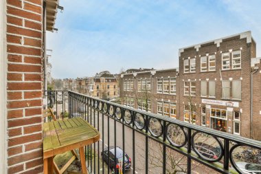 Amsterdam, Hollanda - 10 Nisan 2021: Arka planda bisiklet ve binaların park ettiği bir balkon, apartmanların balkonundan alındı.