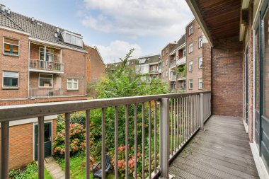 Amsterdam, Holland Caddesi 'ndeki bir apartman dairesinden görüldüğü gibi, parmaklıkların üzerinde bitkiler ve çiçeklerle dolu bir balkon.