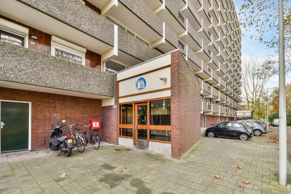オランダ アムステルダム 2021年4月10日 隣に駐車している車のある建物の前に駐輪している自転車 建物の外に駐車している自転車 — ストック写真