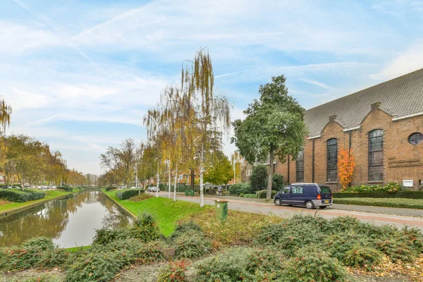2021年4月10日 荷兰阿姆斯特丹 位于市中心的一条河 两边都有房屋和树木 街道两旁都是灌木丛 — 图库照片
