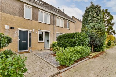 Amsterdam, Hollanda - 10 Nisan 2021: Bahçesinde bitkiler ve çalılar olan bir evin dış görünüşü, güneşli bir gün fotoğrafı.