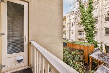 Apartman balkonunun sağ tarafında kapısı, penceresi ve saksısı olan bir yer.