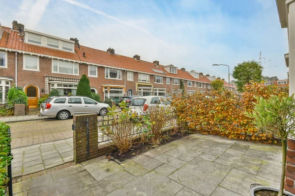 stock image an outside area with cars parked on the street and houses in the background, as seen from another side view