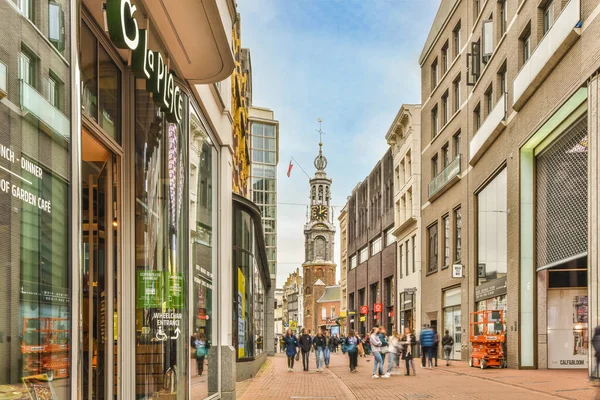 2021年4月10日 荷兰阿姆斯特丹 人们在蓝天上的建筑物和商店前面走着 上面点缀着白云 — 图库照片