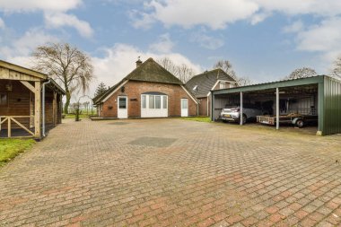 İki garajı ve garaj yolunda yan yana park edilmiş bir arabası olan bir yer.