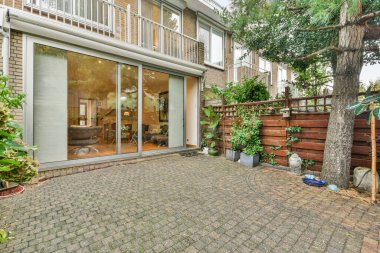 Amsterdam, Hollanda - 10 Nisan 2021: tuğla kaldırımlı ve ön tarafında ağaç olan arka bahçe alanı - görüntü dışarıdan çekildi