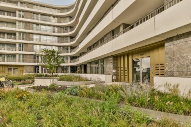 Amsterdam, Hollanda - 10 Nisan 2021: Binanın ön tarafında bitki ve çiçeklerin bulunduğu bir ofis binasının dışı.