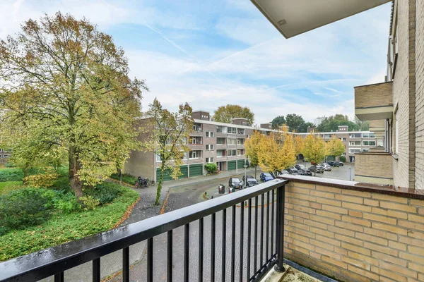 stock image an outside area with trees and buildings in the background, as seen from a balcony looking out onto the street