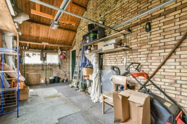 Garajın önünde kutular, aletler ve diğer şeylerle dolu bir garaj var.