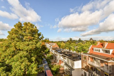 Amsterdam, Hollanda - 10 Nisan 2021: Bazı evler ve ağaçlar gün içinde yatak odamın penceresinden alındı ve aşağıdaki sokağa baktı.