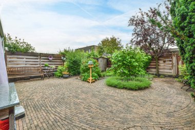 Amsterdam, Hollanda - 10 Nisan 2021: arka bahçesinde yangın musluğu ve çitlerle çevrili arka bahçenin önünde bitkiler olan bir alan