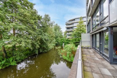 Nehrin her iki tarafında binalar ve ağaçlar olan bir nehrin ortasında nehir.