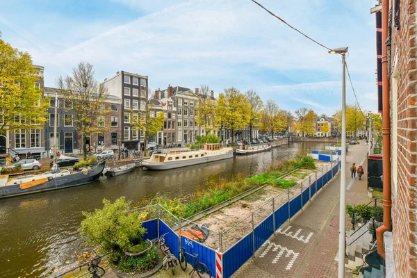 Amsterdã Holanda Abril 2021 Canal Com Barcos Água Edifícios Ambos — Fotografia de Stock