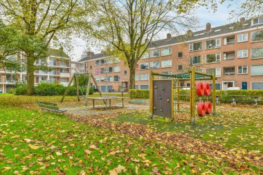 Yapraklarla çevrili oyun alanları ve oyun alanlarıyla Hollanda 'da bir apartman kompleksi.