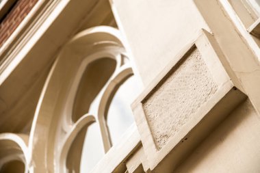 Amsterdam, Hollanda - 10 Nisan 2021: Eski bir zaman makinesinden alınmış gibi görünen bir binanın yanındaki saat