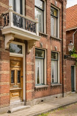 Ön kapısı ve penceresi başka bir binanın girişinin üstünde yazan tuğladan bir bina.